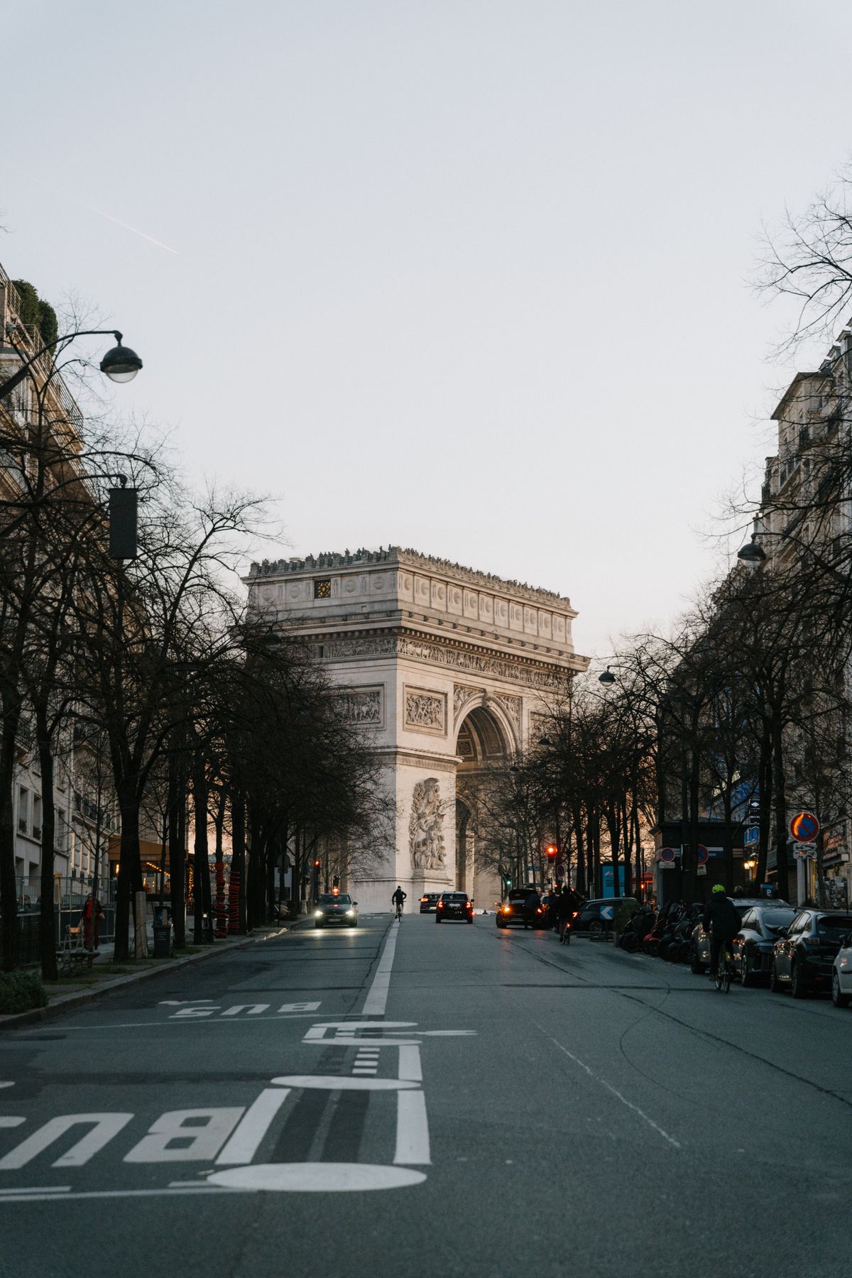 Triumfbuen sett langs en parisisk gate i kveldslys